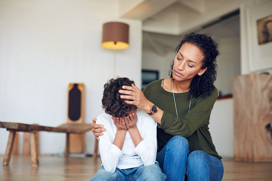 helping your empathetic child manage big feelings. mother comforting son with his head in his hands.