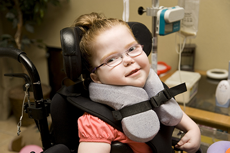 Smiling young girl with cerebral palsy in wheelchair