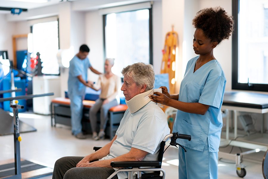 choosing the right rehab. Physical therapist adjusts the neck brace of a patient after physical therapy in a rehabilitation center.